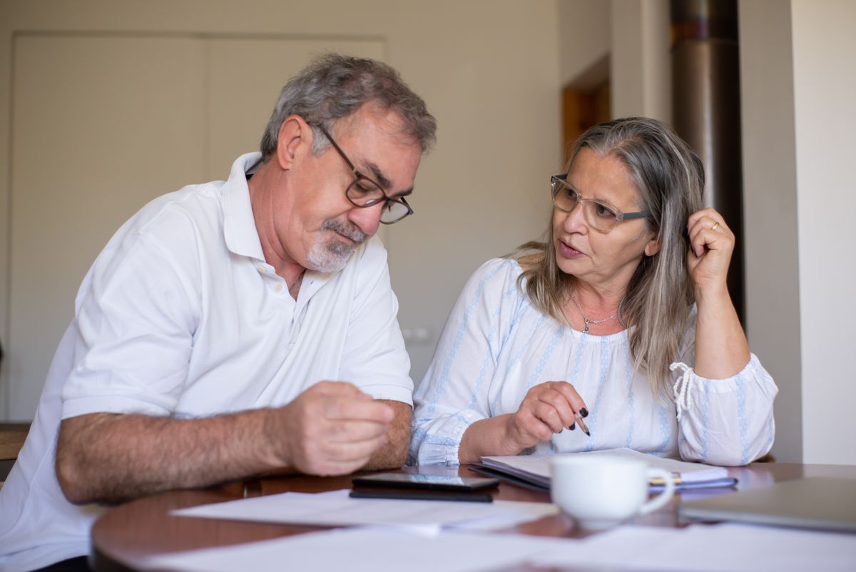 Older couple reviewing paperwork together at home